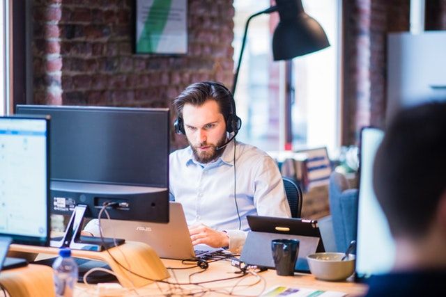 A support engineer working at a desk with a headset